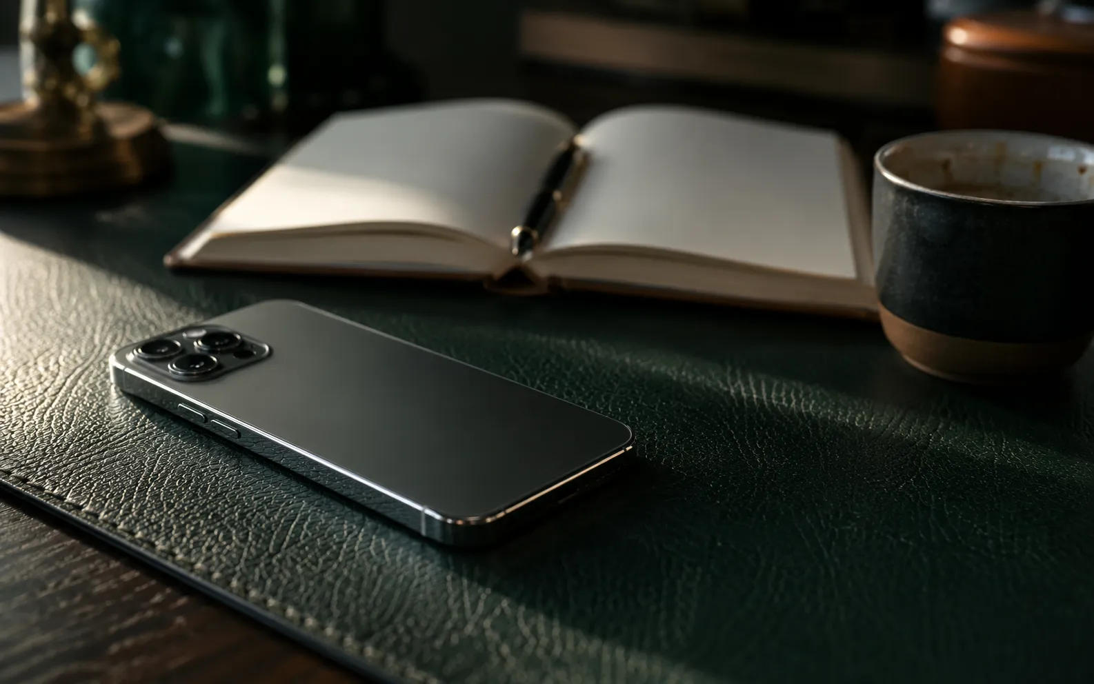 An iPhone face-down on a desk beside a notebook while a call comes in unnoticed
