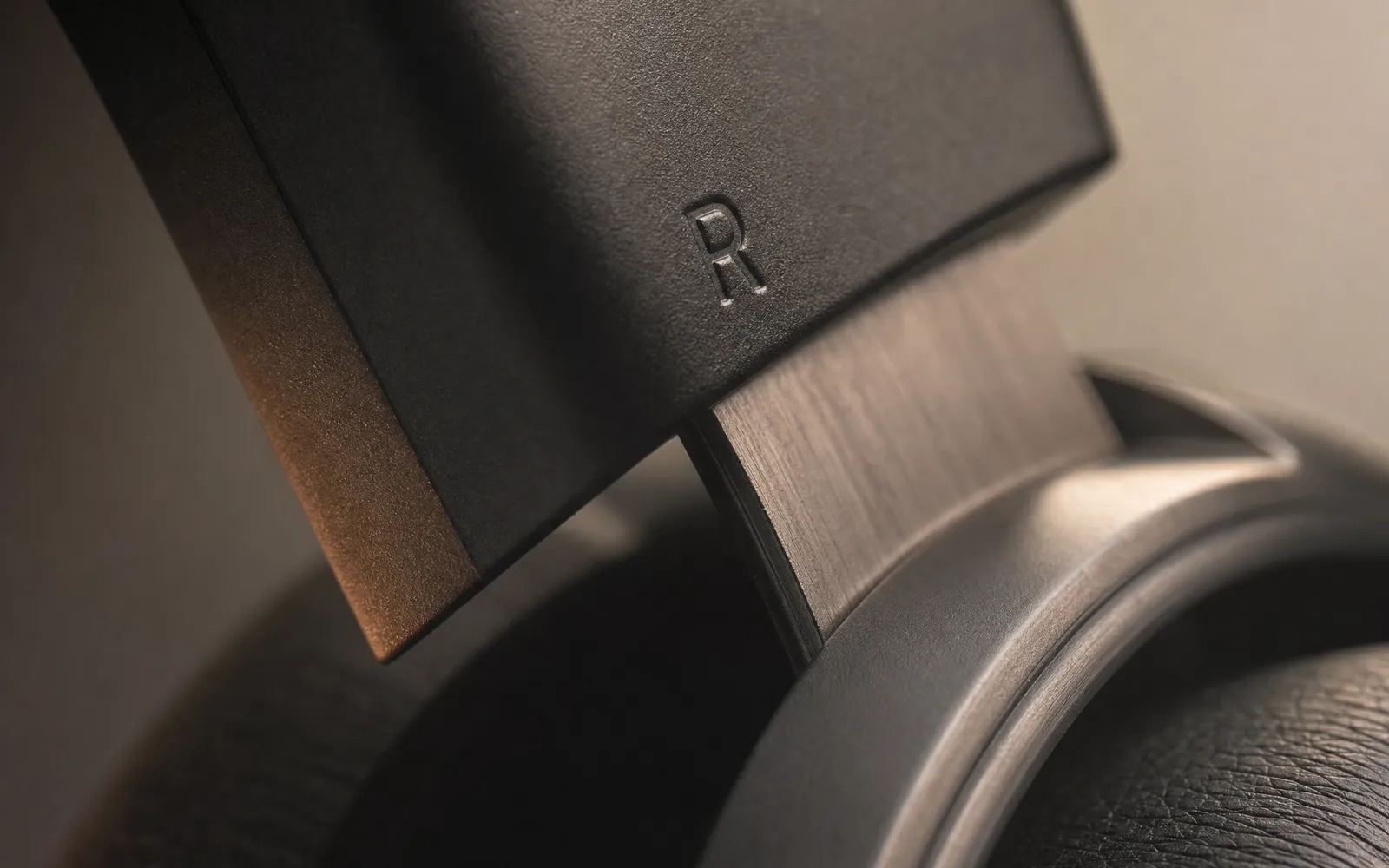 Macro of a headphone ear cup hinge with a small embossed letter R